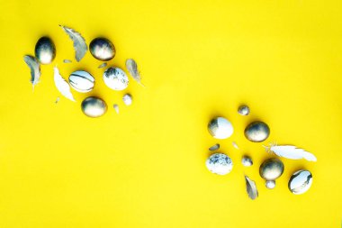 Dekoratif renkli Paskalya yumurtaları ve Sarı zemin üzerine tüy şenlikli Paskalya düz yatırın