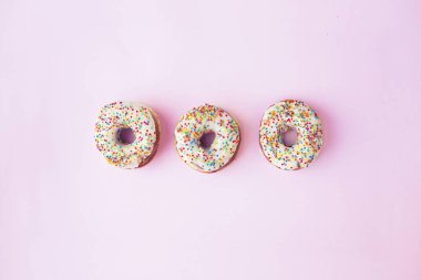 pembe bir arka plan üzerinde tatlı sırlı Donuts üstten görünüm