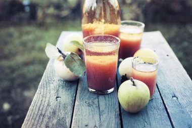 Taze elma suyu kırsalında, yaz konsepti ahşap masa üzerinde gözlük