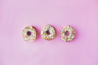 pembe bir arka plan üzerinde tatlı sırlı Donuts üstten görünüm