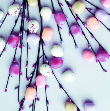 Mavi arka plan üzerinde renkli Paskalya yumurta süslemeli el yapımı willow dal