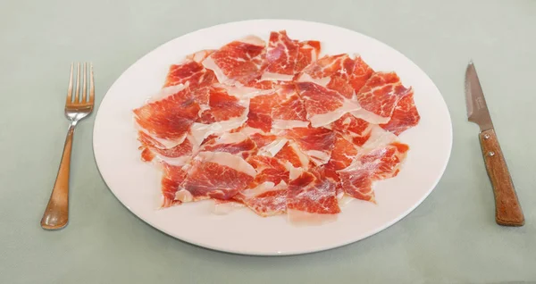 Dry cured ham segmenten op plaat in restaurant — Stockfoto