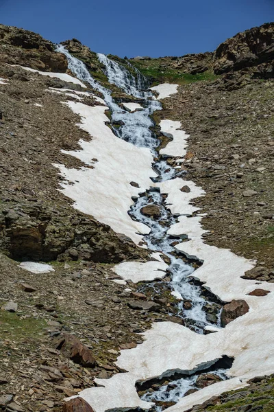 Wasserfall mit Eis und Schneefeldern, vertikale Zusammensetzung — Stockfoto