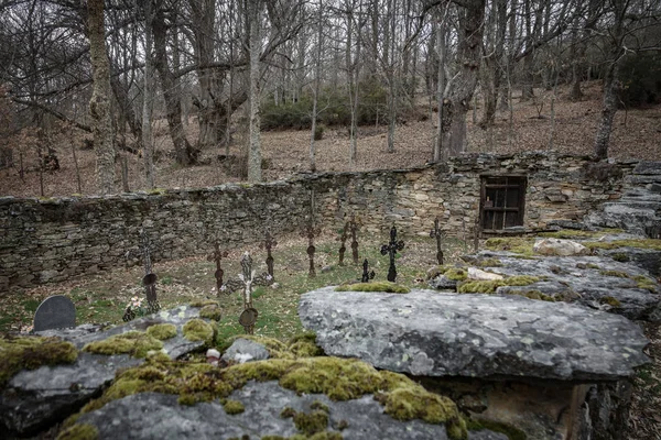 Old vintage cemetery with stone wall and rusty crosses