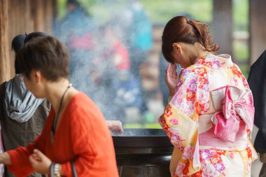 Kyoto, Japonya - 8 Haziran 2015: kimliği belirsiz kadın arkasında dua ediyor Japon sopa Kyoto, Japonya için tapınak tütsü