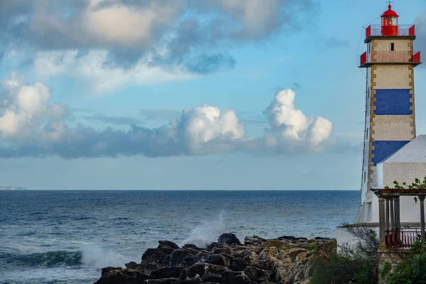 Deniz feneri ve okyanus alacakaranlıkta — Stok fotoğraf