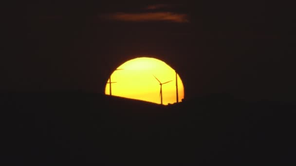 Puesta de sol sobre las colinas con molinos de viento — Vídeos de Stock