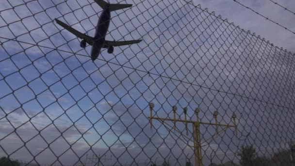 Jet aterrizaje en cámara súper lenta detrás de la barandilla del aeropuerto — Vídeos de Stock