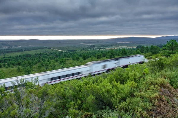 Järnväg och suddig snabba tåg i landet, molnigt himlen — Stockfoto