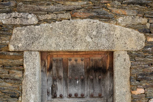 Marco de granito, fachada de piedra y puerta de madera vintage —  Fotos de Stock