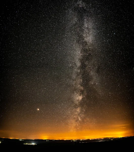 Milky way with many small villages and horizon orange lights — Stock Photo, Image