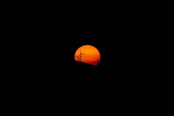 Windmills against orange sunset over the hill — Stock Photo, Image