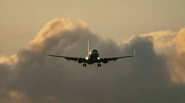 Alto contraste de avión jet aterrizaje contra nubes —  Fotos de Stock