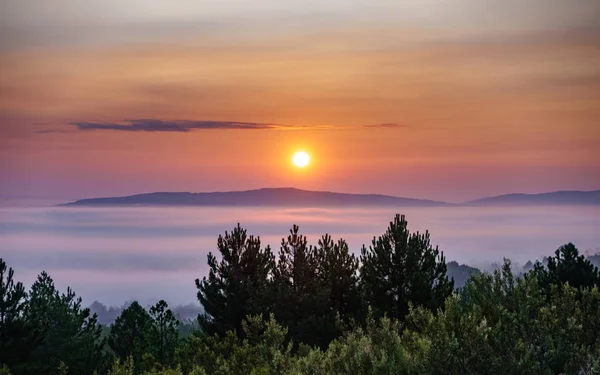 Salida del sol detrás de las montañas con niebla en el valle —  Fotos de Stock