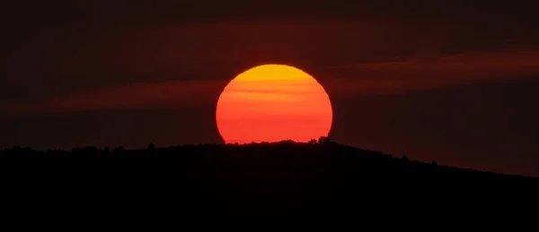 巨大なオレンジ色の太陽と山の頂上のパノラマの日の出 — ストック写真