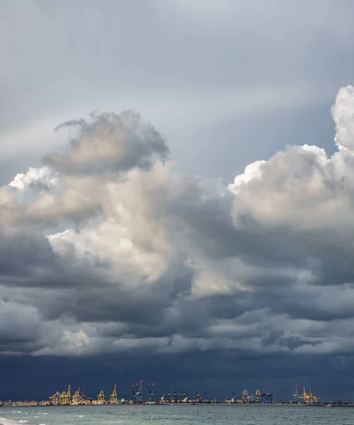 Nubes tormentosas oscuras sobre grúas portuarias y océano —  Fotos de Stock