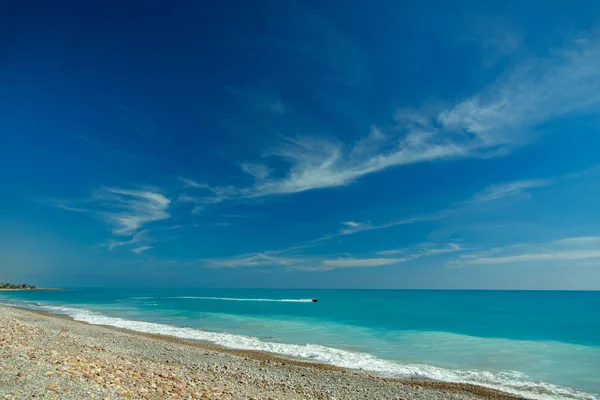 Idylliska sten strand med vatten jet och blå himmel — Stockfoto