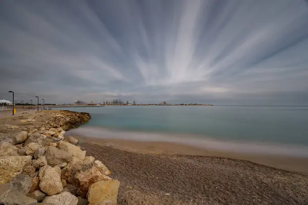 Beach and commercial port with cranes ultra long exposure — Stock Photo, Image