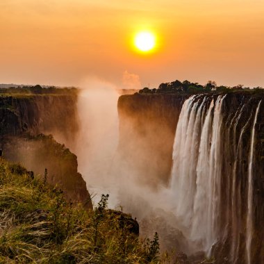 Victoria falls günbatımı turuncu güneş sis arkasında
