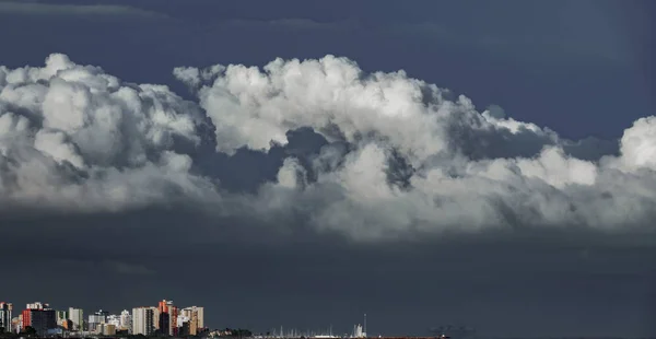 Largo tiro de rascacielos cerca del mar con nubes tormentosas —  Fotos de Stock