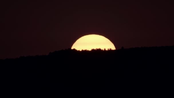 Salida del sol detrás de la colina oscura y el sol naranja enorme — Vídeo de stock