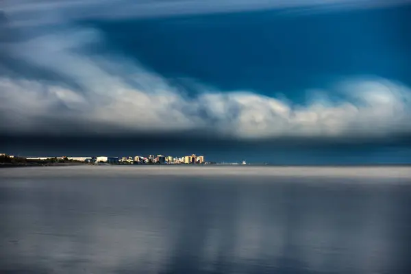 Ultra long exposure of skyscrappers and sea with clouds — Stock Photo, Image