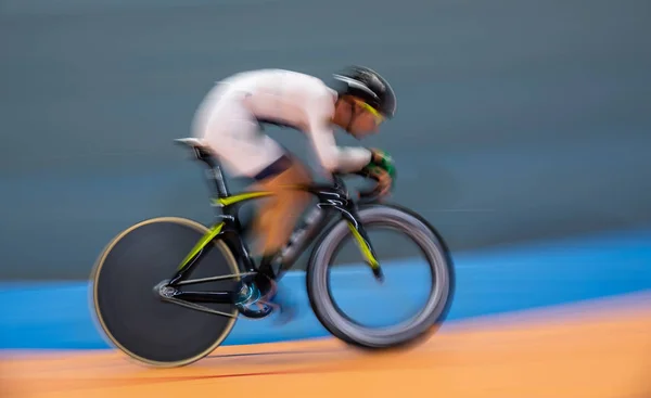 Perfil borroso movimiento de ciclista compitiendo en interiores — Foto de Stock