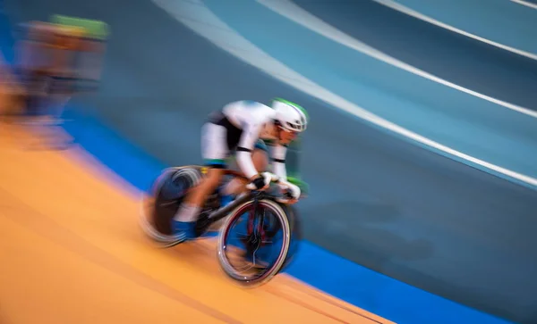 Movimiento borroso de ciclista rápido compitiendo en interiores — Foto de Stock