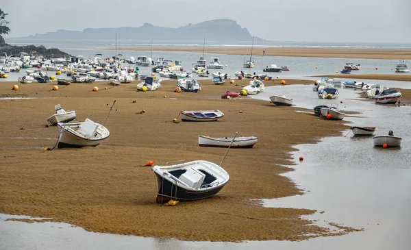 Low tide and boats running aground over the sand