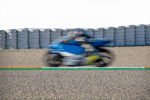 Blurred motion of motorcycle competing in racing circuit and white space — Stock Photo, Image