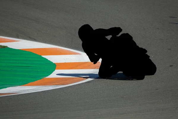 Black motorbike outline of racing pilot tracing curve in circuit — Stock Photo, Image