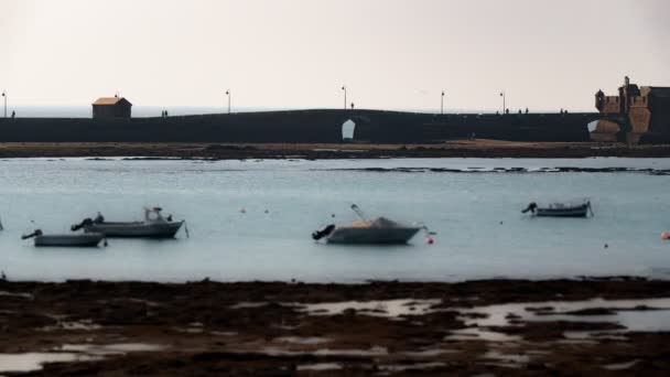 Hoog contrast achtergrondverlichting van wandeling naar fort in Cadiz — Stockvideo