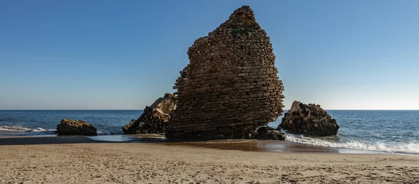 Torre de defensa arruinada en la orilla del océano —  Fotos de Stock