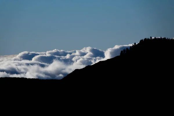 Nuages derrière sombres sommets montagneux, contraste élevé — Photo