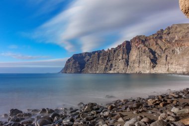Los guios stone beach looking to Los Gigantes cliffs in Tenerife clipart