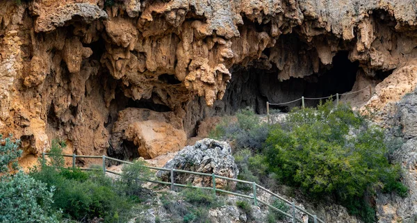 Deep cave with wooden fence path access — Stock Photo, Image