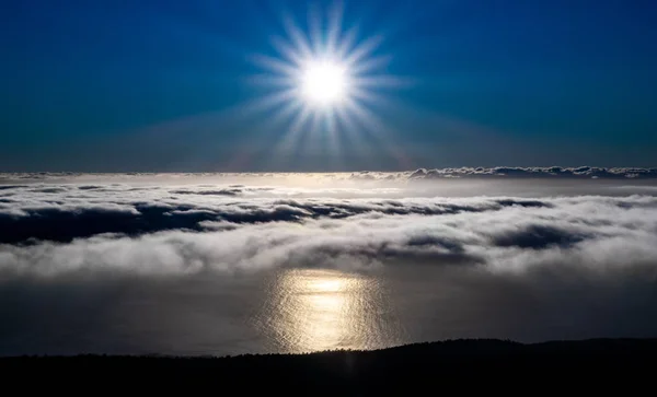 Λαμπερός ήλιος αντανάκλαση στον ωκεανό πάνω από τα σύννεφα κοντά ακτή — Φωτογραφία Αρχείου