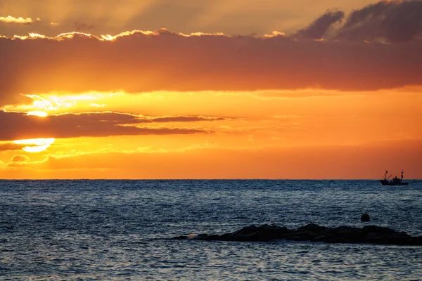 Fischerboot am Horizont des Ozeans bei Sonnenuntergang — Stockfoto