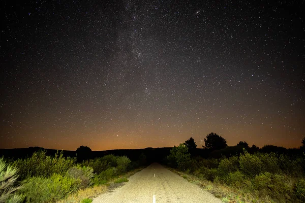 Estrada velha no mato iluminado sob as estrelas — Fotografia de Stock