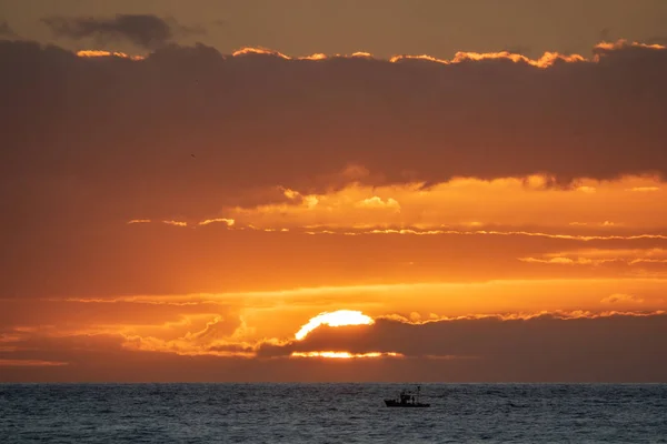 阳光笼罩在海洋天际线上, 有小型渔船 — 图库照片