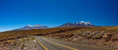 Atacama kavisli yol ve karla kaplı volkanlar panorama