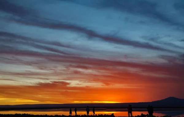 Zachód słońca w Salar z pomarańczowym niebie i turystów — Zdjęcie stockowe