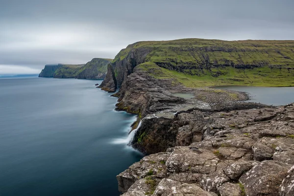 Bosdalafossur cachoeira e costa exposição longa, Ilhas Faroé — Fotografia de Stock
