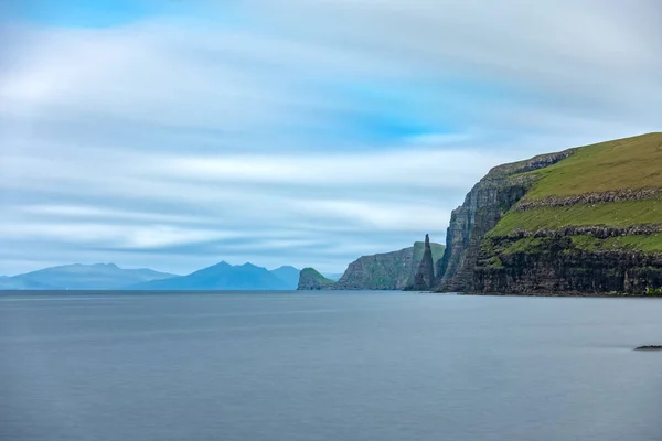 Dik kıyı şeridinde sandoy kaya iğnesi, uzun pozlama — Stok fotoğraf