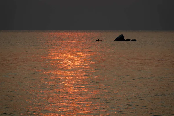 Fisherman fishing near rock at sunrise in Malawi lake, high contrast — Stock Photo, Image