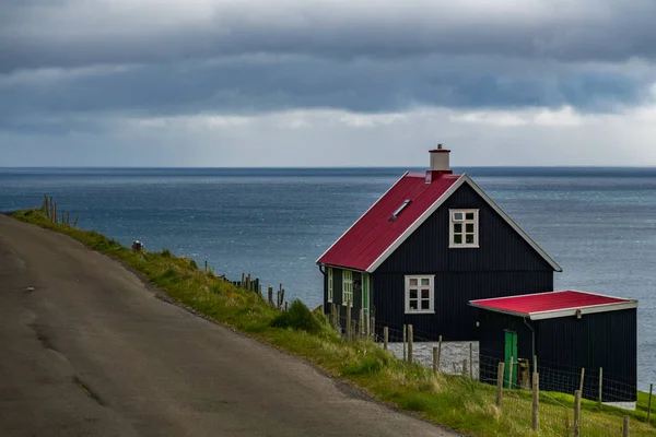 Дом рядом с океаном и дорога на Фарерских островах — стоковое фото