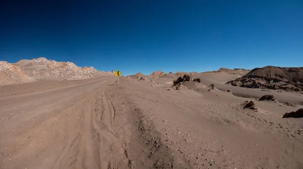 Sinal de estrada curvo no deserto de areia — Fotografia de Stock
