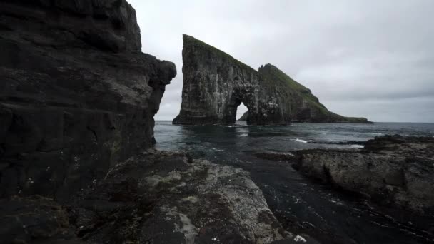 Amazing sliding camera bottom view of Drangarnir gate in front of Tindholmur, Faroe Islands — Stock Video