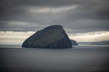Faroe Adaları 'ndaki bulutlu gökyüzünün altındaki ada