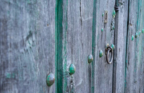 Παλιά κατεστραμένη πράσινη βαμμένη ξύλινη πόρτα και σιδερένια καρφιά — Φωτογραφία Αρχείου